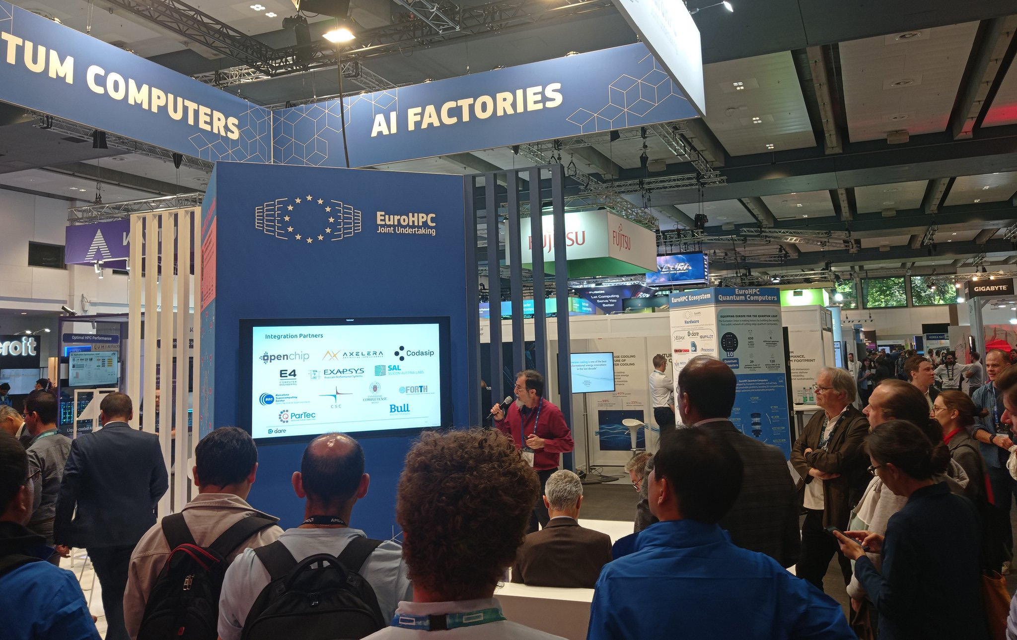 Photo of Osman Ünsal presenting DARE at the EuroHPC JU booth at ISC-HPC 
